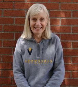 Beverly Burch smiles in front of the admissions building